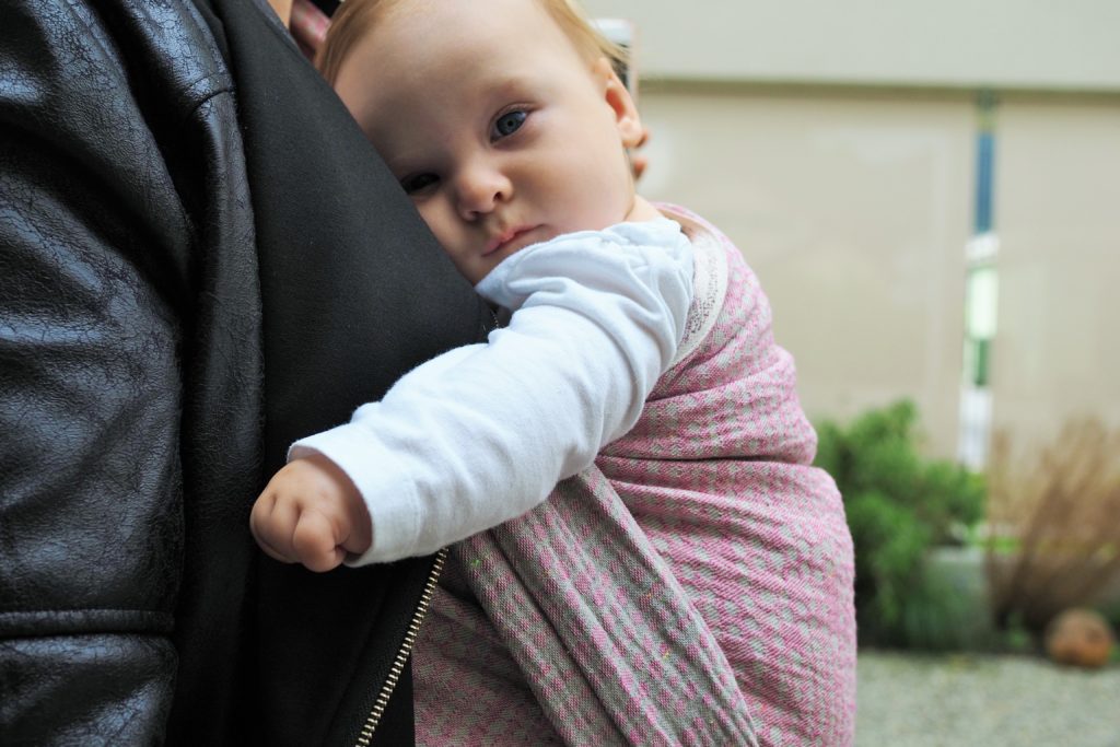 Tragemama mit Baby im Tragetuch von Lovaloom Nestwärme Symboldbild Attachment Parenting
