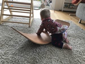 Baby auf gebogenem Brett | Balance-Board das.Brett