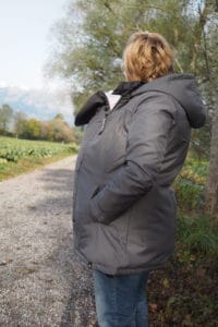 Babywearing mom with baby under babywearing coat Wallaby 2.0 from Wombat London