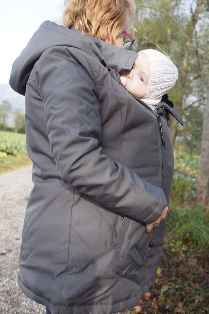 Babywearing mom with baby under babywearing coat Wallaby 2.0 from Wombat London