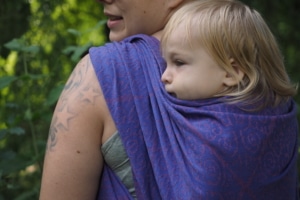baby in a wrap on mamas back